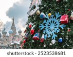 A Christmas tree with toys on Red Square against the background of St. Basil