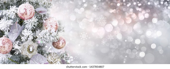 Christmas tree in white frost decorated pink silver balls toys on blurred, fairy background with beautiful bokeh, copy space, wide format. Christmas silvery pink sparkling background.