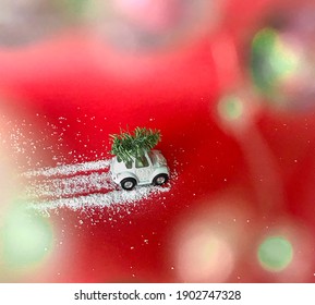 Christmas Tree With White Toy Car Aginst Red Background. Snow Road, Tire Tracks. Top View.