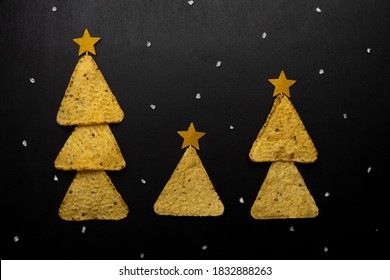 Christmas Trees Made From Nachos Chips With Cheese On A Black Background. Concept For Christmas Night And New Year From Mexican Nachos. Copy Space