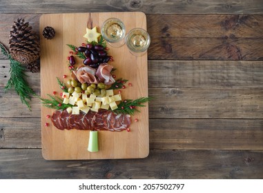 Christmas Tree-shaped Cheese And Charcuterie Appetizer Board With Wooden Base. Top View. Copy Space.