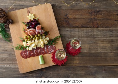 Christmas Tree-shaped Cheese And Charcuterie Appetizer Board With Wooden Base. Top View. Copy Space.