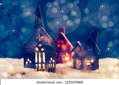 Christmas village made with different candle house, snow, blue background, and beautful bokeh and effect adding mood to the photo, space for adding your text.
 - Powered by Shutterstock