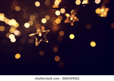 Christmas warm gold garland lights over dark background with glitter overlay - Powered by Shutterstock