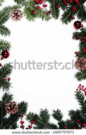 Christmas white blank card with copy space and frame decor of fir tree branch cones red holly berry bauble isolated on white background