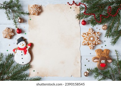 Christmas white wooden background with old paper for greeting text, list, letter to Santa and fir branches, juniper, gingerbread snowflakes, snowman, deer