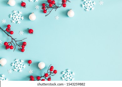 Christmas or winter composition. Snowflakes and red berries on blue background. Christmas, winter, new year concept. Flat lay, top view, copy space - Powered by Shutterstock