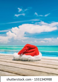 Christmas winter holidays santa hat near swimming pool of Caribbean resort travel vacation destination. Vertical backdrop of paradise vacations.