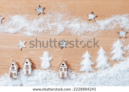 Christmas winter landscape with small houses, artificial snow, stars and trees, flat lay