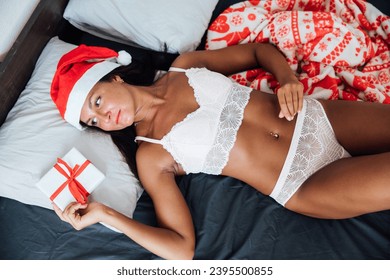 christmas woman in bedroom on bed christmas year gifts - Shutterstock ID 2395500855