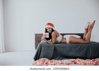 christmas woman in bedroom on bed christmas year gifts - Shutterstock ID 2395500863