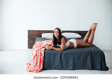 christmas woman in hat in bedroom on bed christmas gifts - Shutterstock ID 2395500841