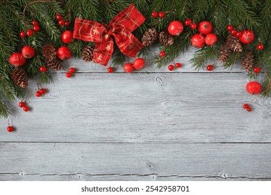 Christmas wooden background with fir branches, red ribbon bow, apples, berries. Copy space, congratulations text. - Powered by Shutterstock