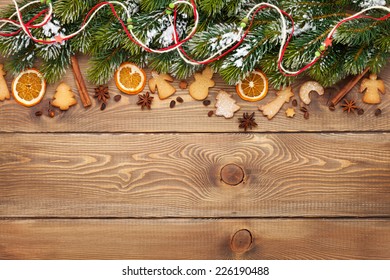 Christmas wooden background with snow fir tree, spices, gingerbread cookies. View from above with copy space - Powered by Shutterstock