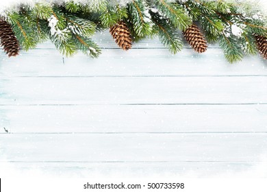 Christmas wooden background with snow fir tree. Top view with copy space for your text
