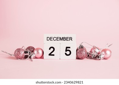 Christmas, wooden calendar with date December 25 and Christmas tree decorations on pink background. Christmas and New Year celebration concept - Powered by Shutterstock