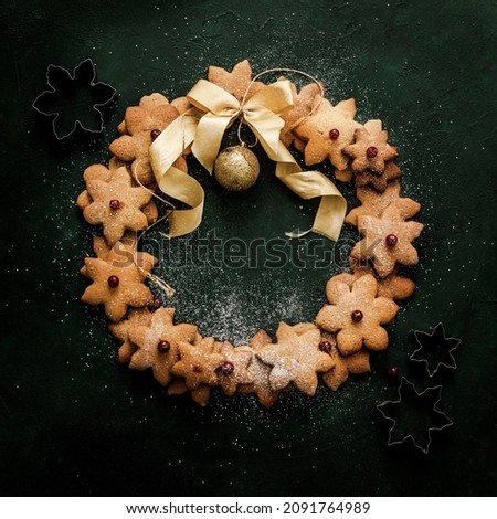 Christmas wreath from gingerbread cookies, on green concrete  surface top view. Christmas evening still-life image.