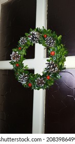 Christmas Wreath On The Door. Green Boxwood Wreath With Pine Cones And Berries.