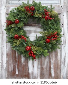 Christmas Wreath On A Rustic Wooden Front Door.