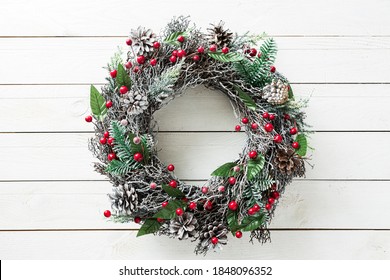 Christmas wreath on white wooden background. Winter holiday - traditional, rustic home decoration. Layout with free copy (text) space.  - Powered by Shutterstock