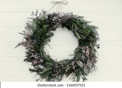 Christmas wreath. stylish rustic christmas wreath on white wooden door with pine cones,fir branches,snow. space for text. handmade decor for winter holidays. - Powered by Shutterstock