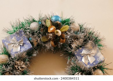 Christmas wreath of Christmas tree tinsel and Christmas tree balls, with cones, with burning garland in golden color close-up horizontally. Handmade Christmas present close-up.  - Powered by Shutterstock