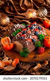 Christmas yule log cake with chocolate cream. Christmas fruit chocolate cake with berries and fruits with edible Christmas decoration - Shutterstock ID 2070179351