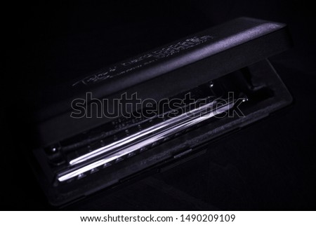 Chromatic harmonica in case as deep blue monochromatic image