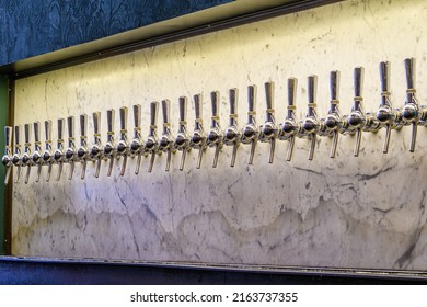 Chrome Beer Taps Against A Marble Wall