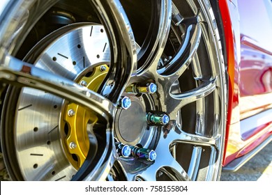 Chrome Rims With A Background Of The Red Side Of A Car. Various Tires At A Southern California Event. 