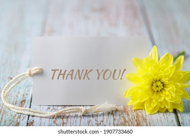 Chrysanthemum flower with Thank You card on aged wooden background