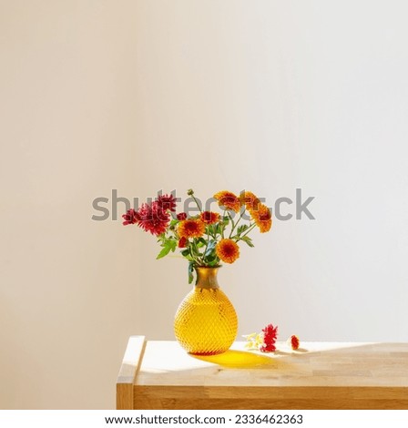 chrysanthemums in glass vase on white background