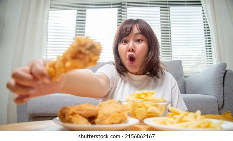 Chubby Asian Woman Express Happiness When Eating Fried Chicken, Fries, And Potato Snacks