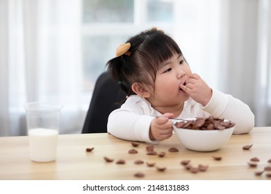 Chubby Child Girl Enjoy Eating Chocolate Cereal On The Table