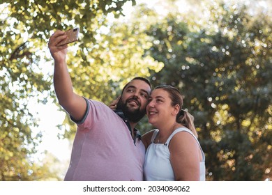 
A Chubby Couple Taking A Picture In A Park.