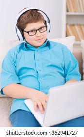 Chubby Kid Playing Games On The Laptop.