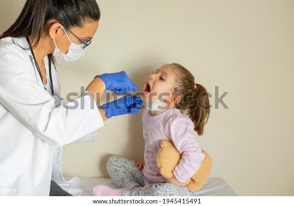 chubby little\
girl in pediatric examination by her doctor. ENT ( Ear, Nose,\
Throat ) Examination. Selective\
Focus