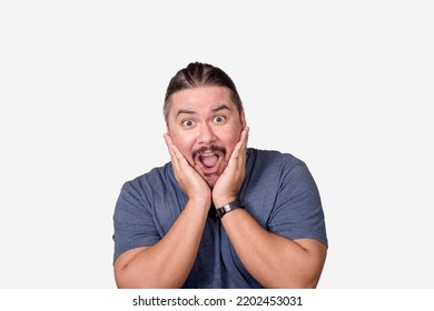 A Chubby Man Exclaims Gosh Feeling Surprised And Amazed With Hands On Cheeks. Isolated On A White Background.