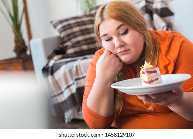 Chubby Woman Sport At Home Sitting On Floor Looking At Cake On Plate Upset Maintaining Healthy Lifestyle Close-up