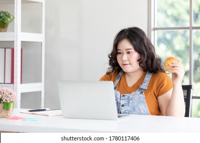 Chubby Woman Working From Home And Holding Hamburger