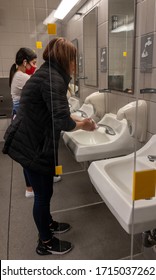 Chula Vista California. USA. April 2020. West Coast. San Diego County. Public Restroom. Plexiglass Shield Protection. Women Washing Hands. Social Distancing.