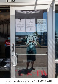 Chula Vista California. USA. April 2020. West Coast Fast Food Employee Using Face Mask. Percaution Signs On Glass Door. Support Local Business During Pandemic. Covid-19.