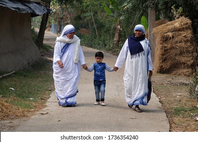 CHUNAKHALI, INDIA - FEBRUARY 26, 2020: Missionaries of Charity - Mother Teresa nuns walk with child in Chunakhali, West Bengal, India