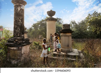 Chunar, UP, India, December 17th, 2012: Kids Playing In A 200 Years Old Abandoned British Graveyard Near Chunar Fort Near The Kaimur Hills In Mirzapur District Of Uttar Pradesh, India