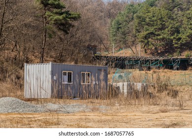 Chungju, South Korea; March 22, 2020: Gray Metal Building In Front Of Ginseng Crop At Rural Construction Site.