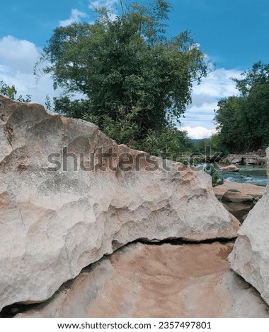 Chunks of limestone rock eroded by the natural flow of the river with a very beautiful blue sky as a background.