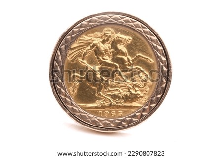 A chunky and heavy gold ring with a gold sovereign coin mounted in it. Isolated on White.