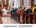 Church altar during Christmas Mass with The Nativity scene. Back view of standing parishioners. The Catholic Orthodox Christmas holiday in Europe.