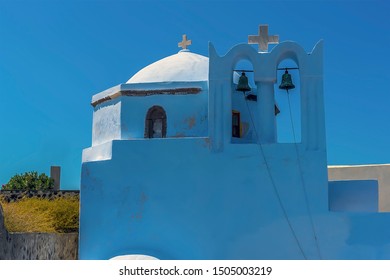 A Church Bell Tower Beside The Castle Ruins In Pyrgos, Santorini In Summertime