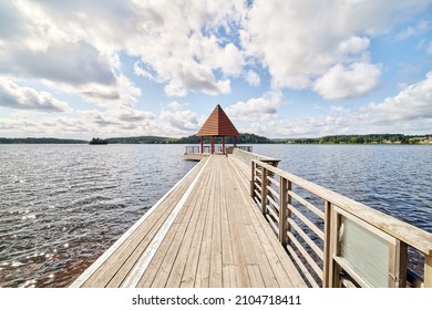 The Church Bridge (Kyrkbryggan), a wooden bridge with pavilion out in the large Lindesjön lake (Stora Lindesjön) right at the foot of Lindesberg church in the town of Lindesberg.